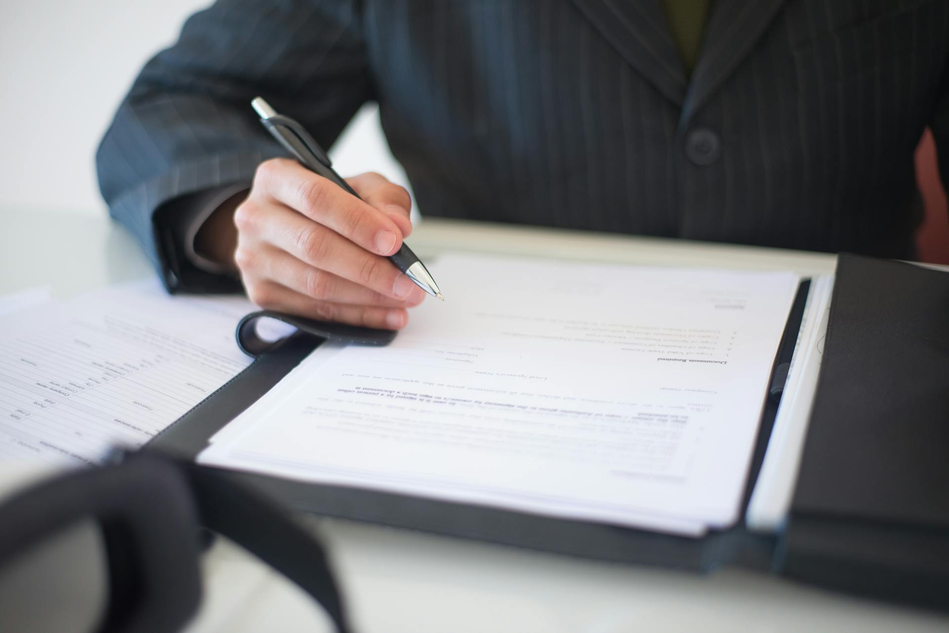 a person holding a pen signing a document