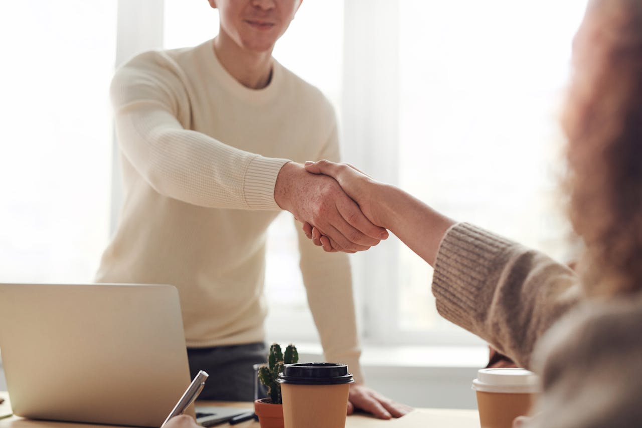 a property manager and qualified resident shake hands